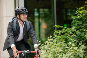 Morning ride. Young smiling businessman on a bike