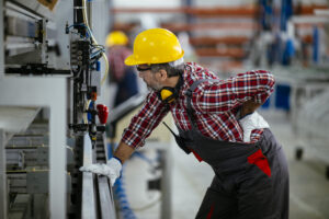 Factory worker with painful back injury stock photo. Shadow DOF. Developed from RAW; retouched with special care and attention; Small amount of grain added for best final impression. 16 bit Adobe RGB color profile.