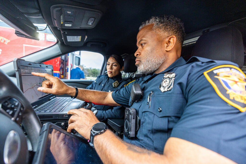 Police Officer Partners in Vehicle using technology to do their job