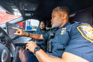 Police Officer Partners in Vehicle using technology to do their job
