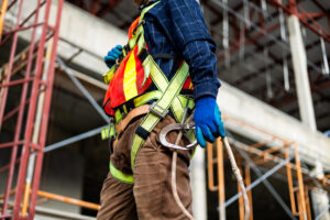 Close-up of a construction worker holding a safety lanyard and snap hook.