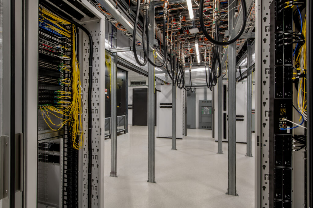 Large data center under construction with fiber optic cables and racks.