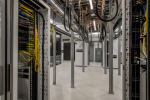 Large data center under construction with fiber optic cables and racks.